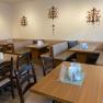 Cozy breakfast area with wooden tables and upholstered benches, decorated with wall ornaments.