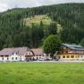 Gasthof Furtner in front of a wooded hill.