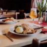 Roast pork with dumplings and beer in a cozy restaurant.
