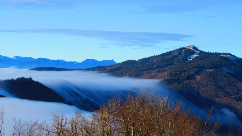 View from a mountain of mist-covered valleys and wooded hills.