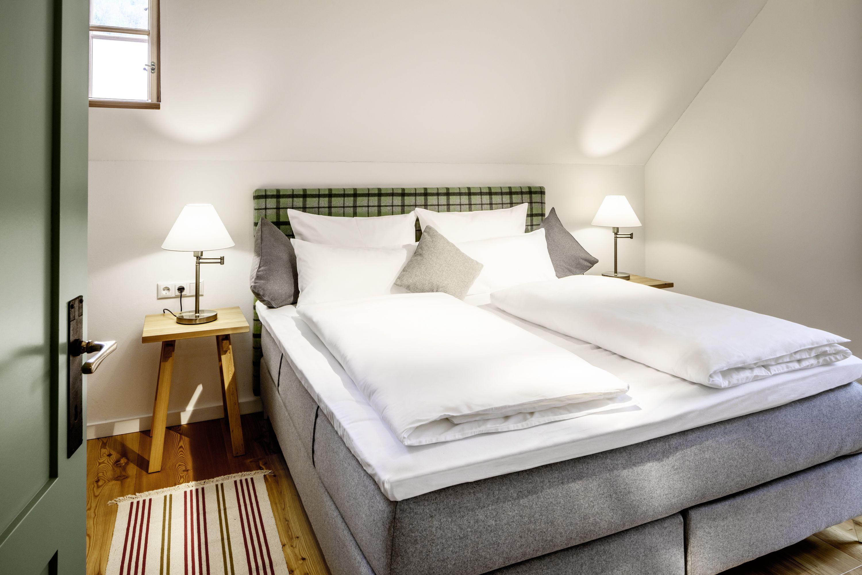 Comfortable hotel room with double bed, bedside tables and lamps.
