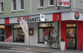 Exterior view of a sports store called Strametz with skis and sportswear in the shop window.