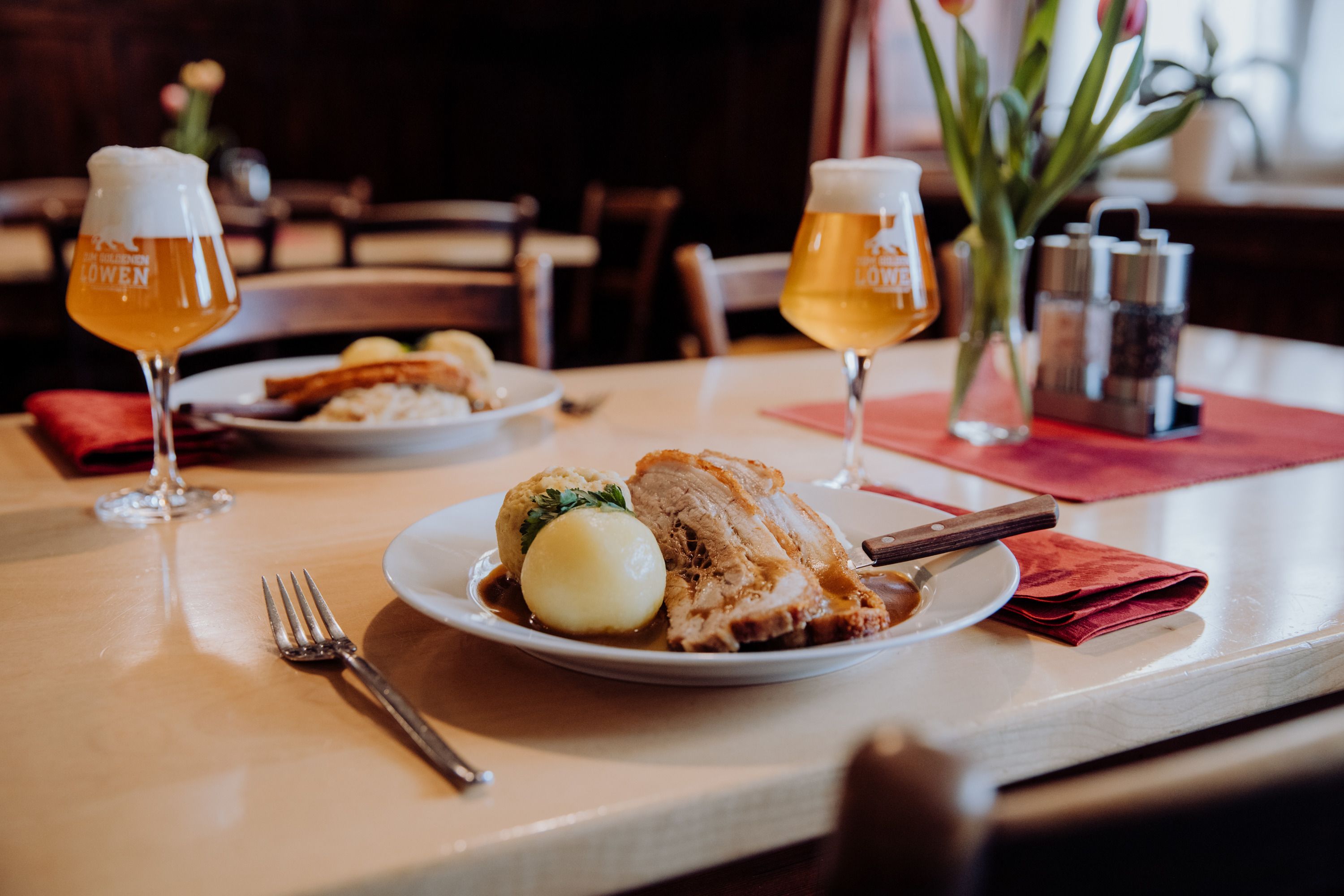 Roast pork with dumplings and beer in a cozy restaurant.