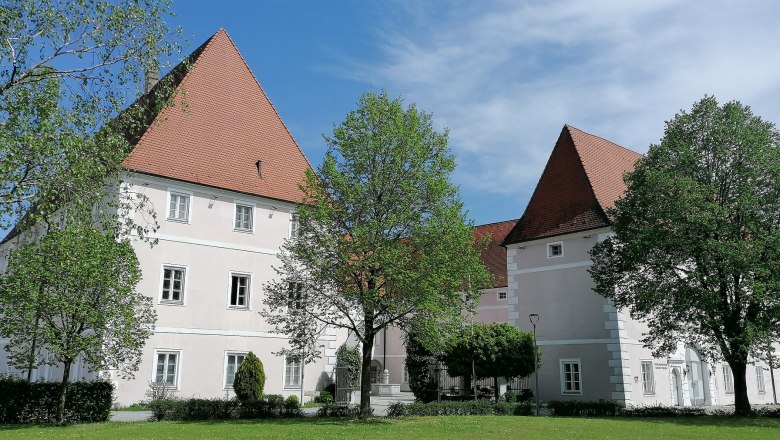 Schloss Hotel Zeillern with green meadow and trees in the foreground.