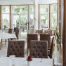 Interior view of an elegant restaurant with set tables and large windows.