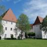 Schloss Hotel Zeillern with green meadow and trees in the foreground.