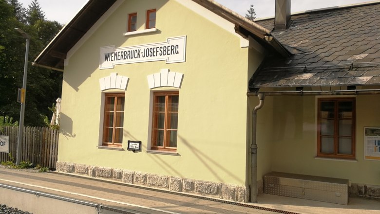 Wienerbruck-Josefsberg station building with yellow fa&ccedil;ade and slate roof.