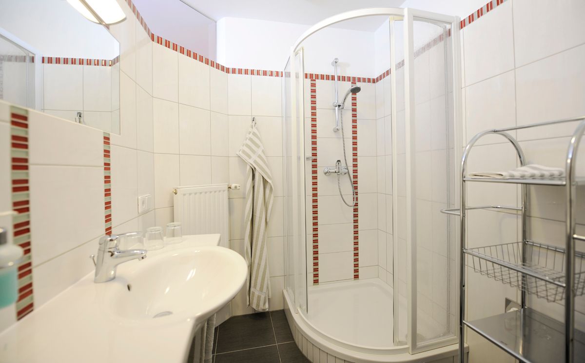 Modern bathroom with shower and washbasin.