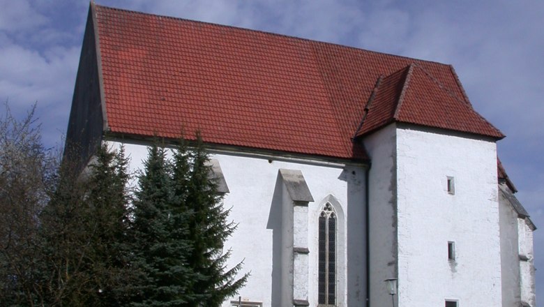 St. Andrew's Church in Kirchberg an der Pielach with a red tiled roof and white fa&ccedil;ade, surrounded by trees and a path in the foreground.