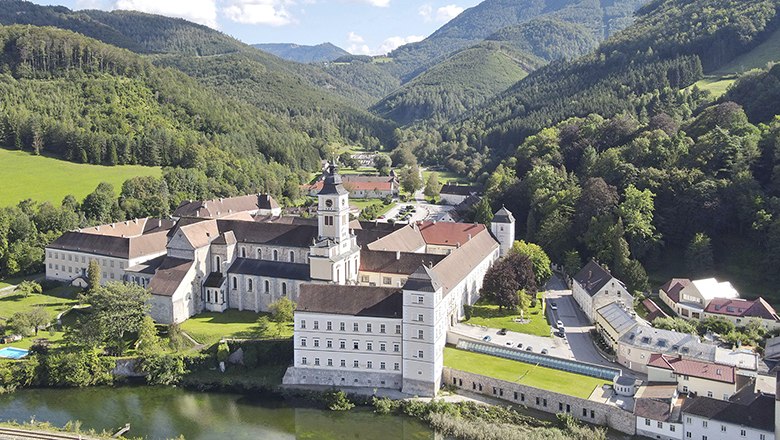 Aerial view of Lilienfeld Abbey surrounded by green hills and forests.