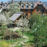 A hotel in the Dirndl Valley with blossoming trees and a garden.