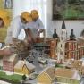Three people decorate a gingerbread model of Mariazell around 1800.
