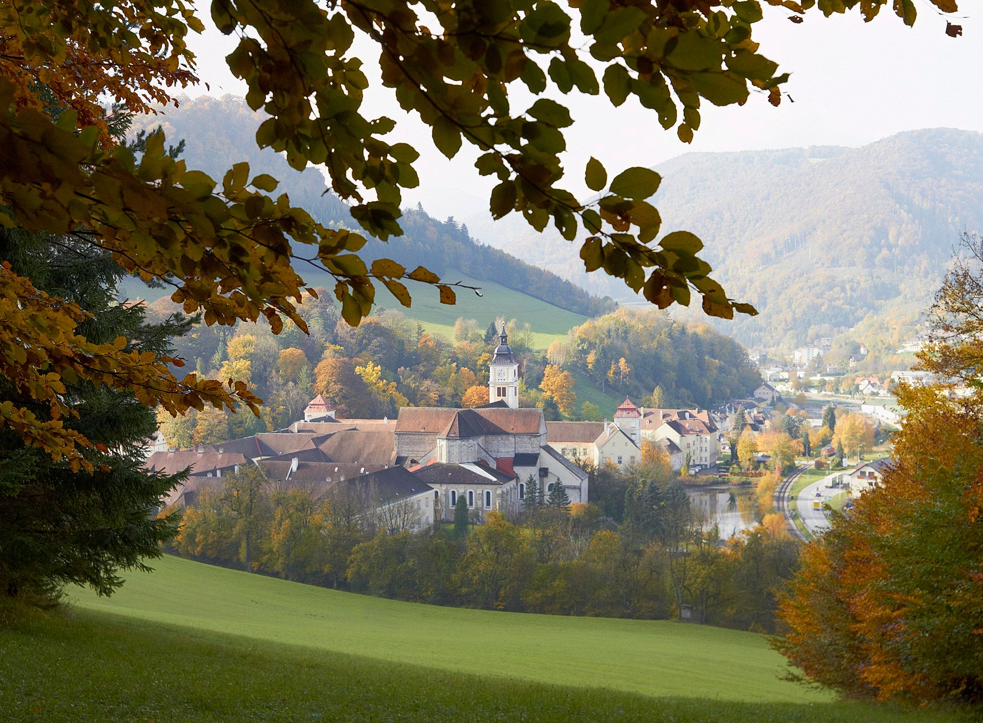 Lilienfeld Abbey in autumn with colorful foliage and surrounding hills.
