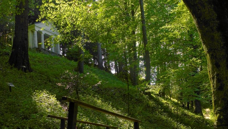 A small temple in Lilienfeld Abbey Park, surrounded by dense forest and green foliage.