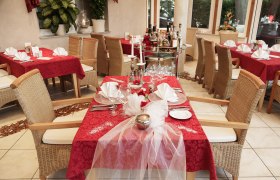 Elegant restaurant with red tablecloths and laid tables.
