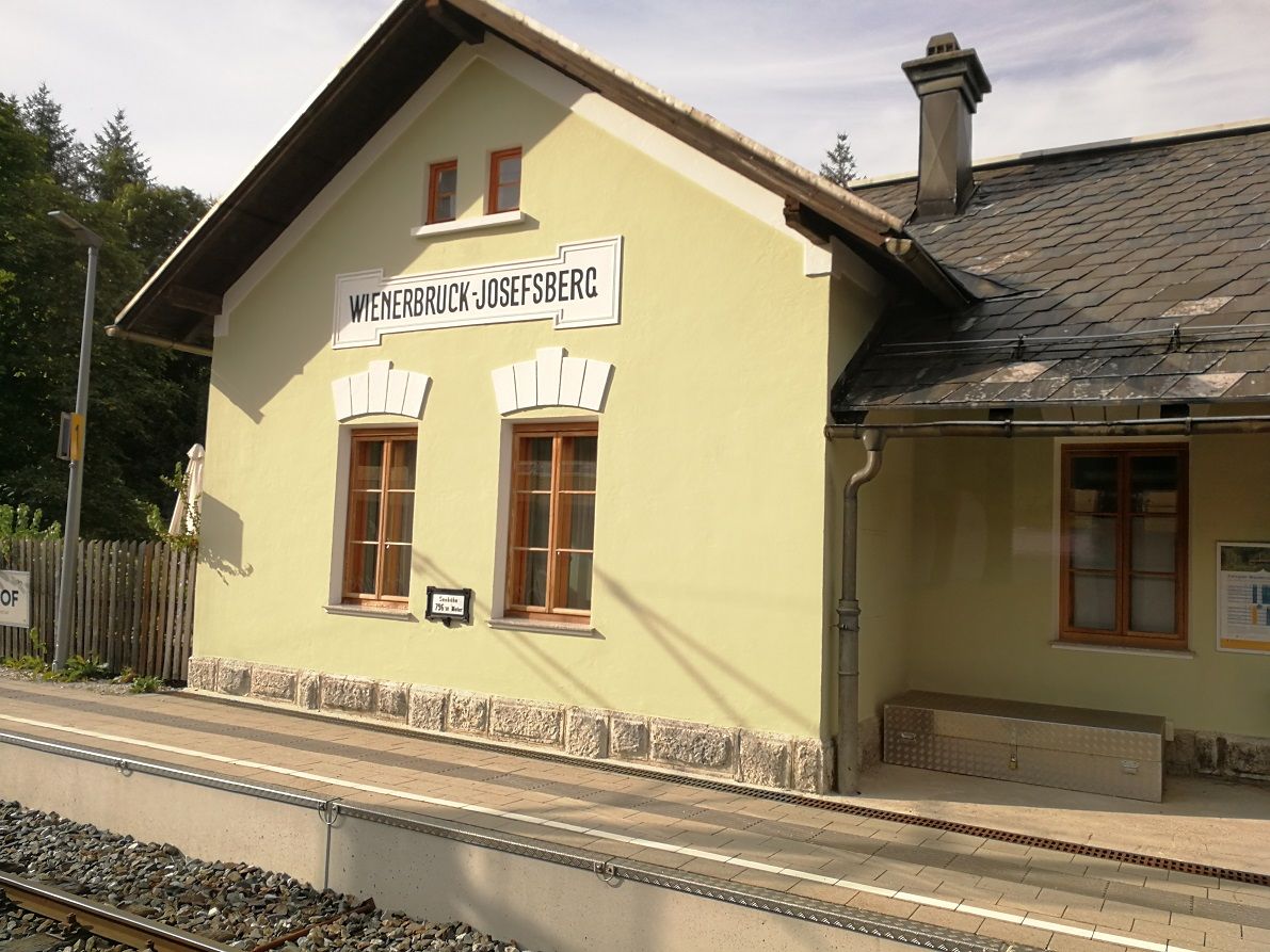 Wienerbruck-Josefsberg station building with yellow façade and slate roof.