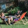 Three people relax on sun loungers in the garden.