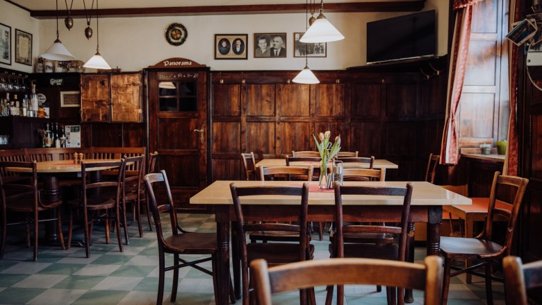 Cozy, traditional inn with wooden furniture and decorative pictures.